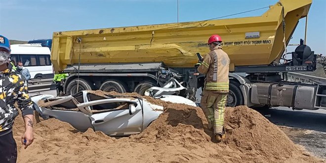 Kum yüklü tır, otomobilin üzerine devrildi