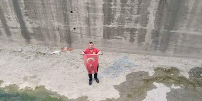 Dere yatağına düşen Türk bayrağı itfaiye ekiplerince çıkarıldı