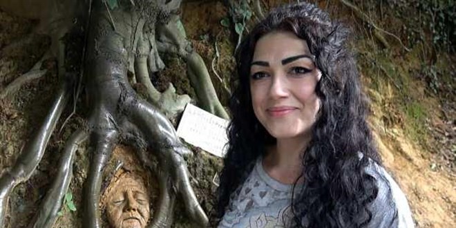 Ağaç köklerini sanat eserine çevirip bir de not bırakıyor