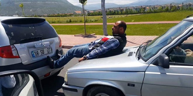 Hareket halindeki aracın kaputunun üzerine oturup, ayaklarıyla öndeki aracı ittiler